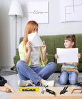Mother and daughter playing with paper in living room, Kids Real Tools Set 30 Piece Builders Kit With Tool Box visible on the floor.