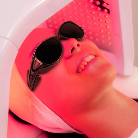 Woman smiling while wearing Straight Up Rock Solid Red Light Therapy Glasses And Eye Protection Goggles For 660nm 850nm Nir, under therapy light.