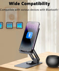 Smartphone on adjustable stand beside pocket-sized Bluetooth speaker with deep bass and crisp highs, 5W stereo sound, on a table.
