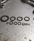 72 Piece Set Double Tooth Lock Washers Black Ironclad Grip 65mn Steel Self Locking Wedge Hardware arranged on a metal surface.