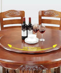 Big Ol Solid Wood Lazy Susan Turntable Rotating Serving Tray With Buttery Smooth Glide Swivel Base For Dining Tables Kitchen Islands And Party Buffets on a dining table with wine and glasses.