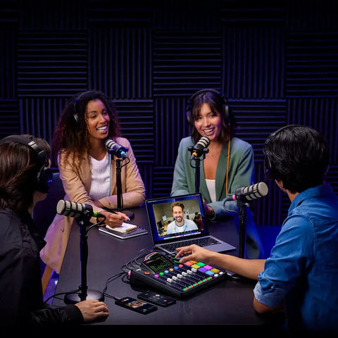 Killer Podcast Creator Kit Featuring Rodecaster Pro Two Mixing Board in use by four hosts with microphones and laptop.