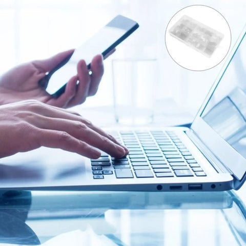 Person using laptop while holding smartphone, showcasing multitasking in a modern workspace with a clean design.