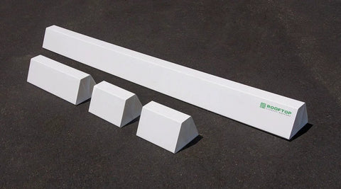 Front view: 36-inch white PVC rooftop support bar with four white wedge blocks on asphalt; ROOFTOP logo.