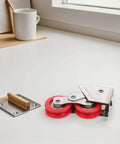 Heavy Duty Stainless Steel Double Roller Sliding Door Replacement Pulleys with red wheels on a white surface next to a wooden door stopper.