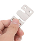 Hand holding a stainless steel interlocking clip from the Six Pair Heavy Duty Picture Frame Hangers for secure wall mounting.