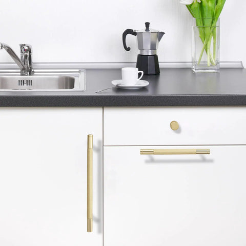 30 Pack 5 Inch Brushed Gold Knurled Cabinet Handles And Drawer Pulls Heavy Duty on white kitchen cabinets with black countertop.