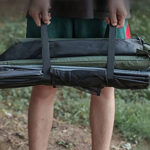 Person holding a rolled-up tent with straps, showcasing 4 Pack Heavy Duty Luggage Tie Straps Featuring Swivel Hog Ring Hooks For Roof Rack Cargo And Truck Bed Hauling Secure Your Gear With Zero Sweat On Long Drives.