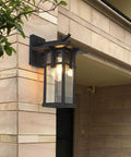 Top Shelf Outdoor Wall Light Built Tough With Square Aluminum Frame And Clear Glass Water Resistant IP54 E27 Socket Classic Sconce mounted on a wall.