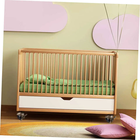 Modern wooden crib with a green mattress and storage drawer, ideal for baby rooms, featuring smooth-rolling wheels.
