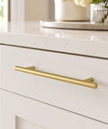 Real Deal 5 Pack Solid Brass Cabinet Pulls Featuring A Stunning Brushed Gold Finish That Delivers Badass Durability And Zero Rust Hassle While Giving Your Cabinets A Major Glow Up Using Simple 6 1 4 Inch Mounting Spacing, close-up view of a gold cabinet pull installed on a white cabinet.