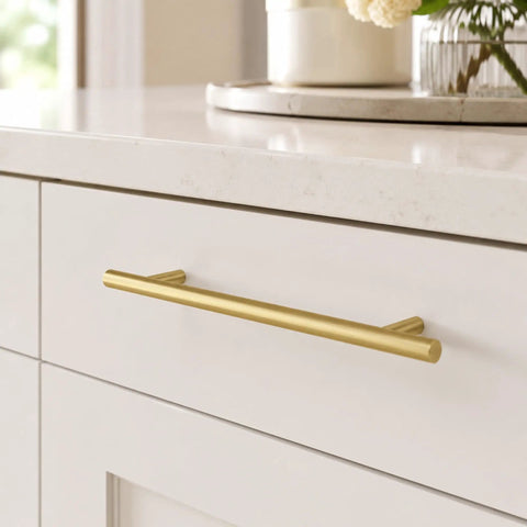 Real Deal 5 Pack Solid Brass Cabinet Pulls Featuring A Stunning Brushed Gold Finish That Delivers Badass Durability And Zero Rust Hassle While Giving Your Cabinets A Major Glow Up Using Simple 6 1 4 Inch Mounting Spacing, close-up view of a gold cabinet pull installed on a white cabinet.