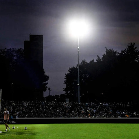 Badass 600W Led Outdoor Stadium Flood Light 48000 Lumen lighting a sports field at night with a large audience.