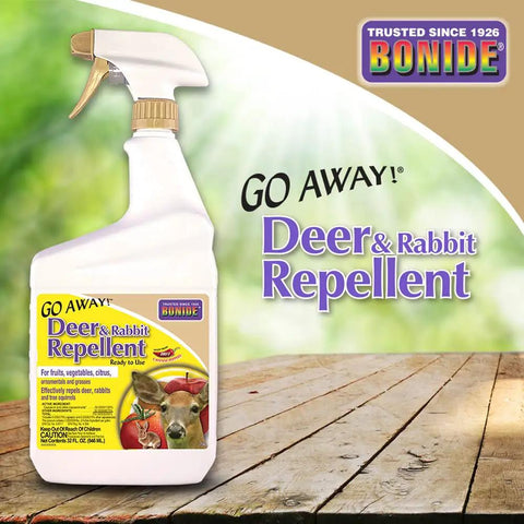 Go Away Deer And Rabbit Repellent Spray 32 Oz Ready To Use Hot Pepper Formula bottle on wooden surface with green background.
