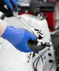 Close-up of a gloved hand using a ratchet handle from the 12 Piece Spark Plug Socket Set With 3/8 Inch Drive on a spark plug.