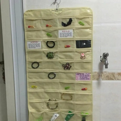 Double Sided Hanging Jewelry Organizer Bag With Eighty Clear Storage Pockets For Earrings Necklaces And Brooches Portable Closet Accessory Holder displaying hair accessories.