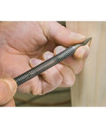 Hand holding a sleek Badass Nail Set Fits 1/32 To 2/32 Inch Brads for precise nailing in fine carpentry.