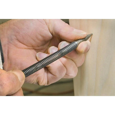 Hand holding a sleek Badass Nail Set Fits 1/32 To 2/32 Inch Brads for precise nailing in fine carpentry.