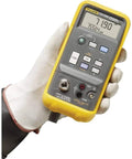 Slick One Hand Electric Pressure Calibrator with digital display and controls held in a gloved hand for precision calibration.