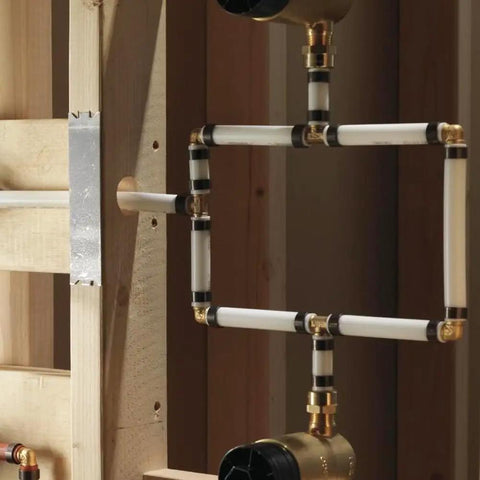 Installed brass PEX crimp fitting kit in use with visible straight, elbow, tee, and four-way fittings for plumbing connections
