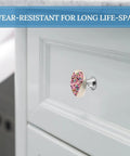 Hand Painted Heart Cabinet Knobs Two Pack Slick Round Drawer Pulls With Sturdy Stainless Steel Base and Mounting Hardware For Dresser Wardrobe Kitchen Furniture Knockout Glow Up on a white cabinet.