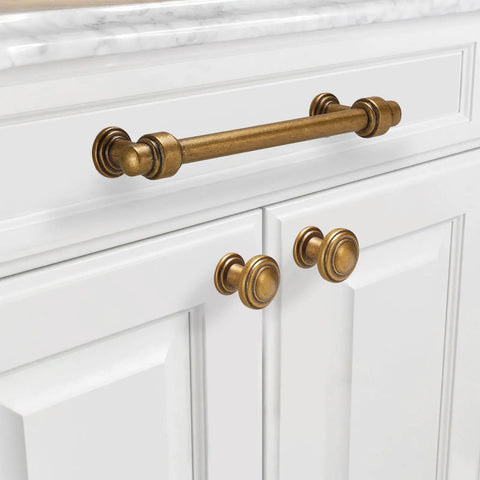 10 Pack 5 Inch Antique Brass Cabinet Pulls Solid Zinc Alloy Drawer Handles on white cabinetry, providing vintage style for cupboards.
