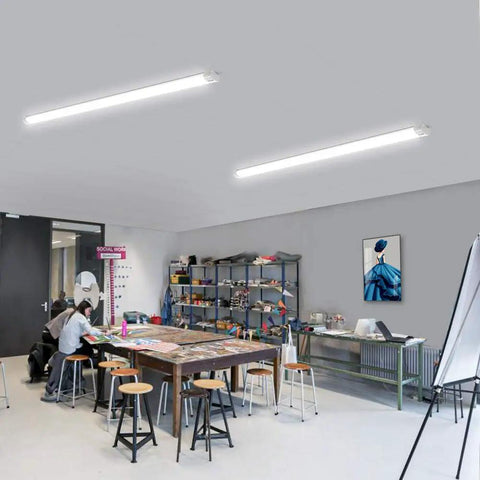 Brightly lit room with Two Pack Linkable LED Shop Lights 2ft And 4ft Waterproof Tubes 5000K under cabinet lighting, workshop setting.