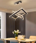 Lit LED Two Ring Rectangular Crystal Chandelier Pendant Light In Stainless Steel over dining table.