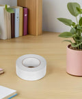 Heavy Duty Clear Tape That Really Slaps For Crafts Wall Mounts Zero Residue Easy Peel Stick Fix on a desk next to a plant.