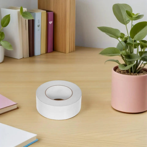 Hella Strong Double Sided Adhesive Tape 5Cm X 164 Feet Pet Roll on a wooden desk with books and a potted plant.