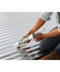Person using Clear Silicone Gutter Caulk 10.1 Oz, Fast-Setting Exterior Sealant for Gutters and Roof Edges on metal roof