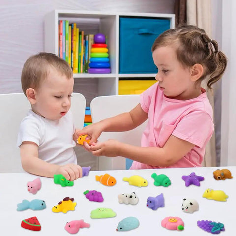 Two kids playing with 30 Pack Totally Rad Squishy Toys Mini Kawaii Mochi Squeeze Buddies on a table, soft colorful critters.
