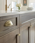 Close-up of a cabinet with a golden champagne knob from the Ten Pack 1 1 4 Inch Round Cabinet Knobs Finished In Premium Golden Champagne Tone For Traditional Kitchen Drawers And Furniture.