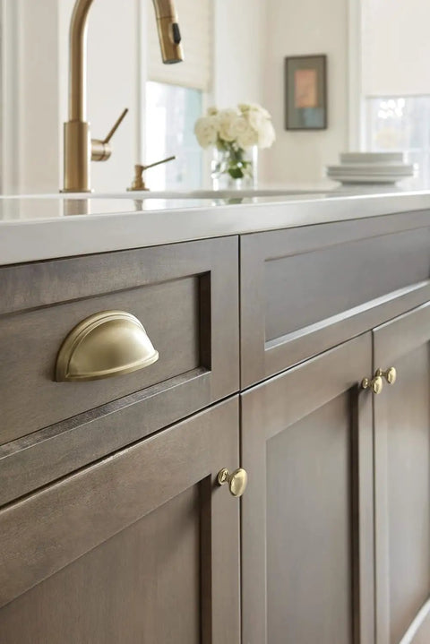 Close-up of a cabinet with a golden champagne knob from the Ten Pack 1 1 4 Inch Round Cabinet Knobs Finished In Premium Golden Champagne Tone For Traditional Kitchen Drawers And Furniture.