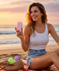 Woman holding Grab and Go Disposable Soap Sheets Set by the beach, showcasing 5 boxes of fragrant paper soap for travel and outdoor use.