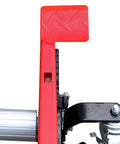Close-up of Heavy Duty 1500 Lb Wheel Dolly Rock Solid Ratchet Lift's red safety foot pedal and locking caster mechanism.