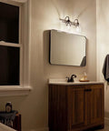 Avery 14.75 Inch Two-Light Vanity Light With Clear Seeded Glass In Olde Bronze above bathroom mirror and wooden vanity.