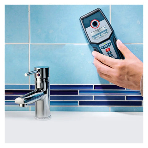 Stud Finder Wall Scanner with AC DC Voltage Test to Bust Hidden Wooden Studs Copper Pipes PVC Water Lines and Live Wires from Behind Drywall Using Wireless Depth Feedback and Tunable Sensitivity used to locate wires behind blue tiled wall.