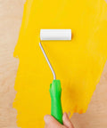 Small paint roller cover applying bright yellow paint on a surface, ideal for quick home makeovers.