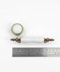 Slick Vintage Style Antique Bronze And White Crackled Ceramic Cabinet Pull And Knob Set Of Eight Pieces on ruler for scale.