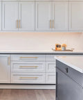 Sleek Knurled Gold Cabinet Pulls For Kitchen Drawers Top Shelf Hardware on white and gray kitchen cabinetry.