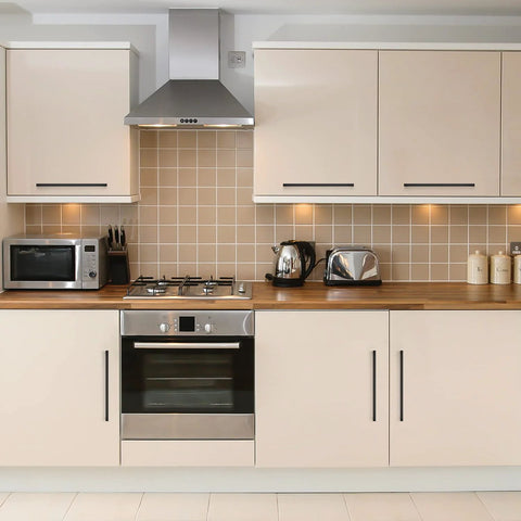 Modern kitchen with 12.6 Inch Square Cabinet Handles Matte Black Pulls on cream cupboards, featuring stainless appliances and wood countertop.