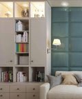 Modern living room with beige storage cabinet, bookshelves, blue accent wall, and a cream sofa with cushions.