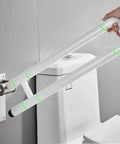 Built Tough Twenty Eight Inch Flip Up Toilet Grab Bar With Rock Solid Stainless Core And No Slip Abs Handle For Wall Mount Bathroom Setup Easy Secure Install For Seniors Or Post Surgery Recovery White, being held and installed next to a toilet.