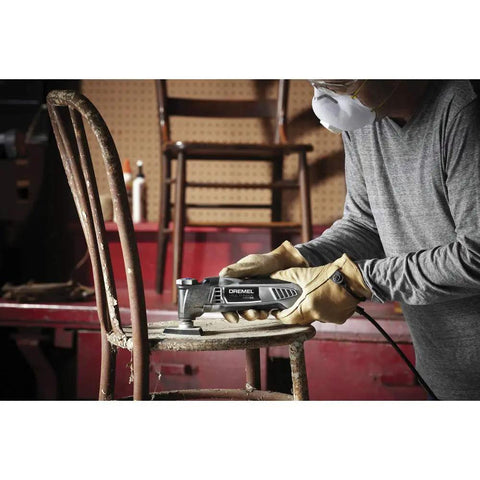 Person using Pro Grade Corded Oscillating Multi Tool Kit 120V 3.5 Amp Power, Reconditioned, on chair in workshop
