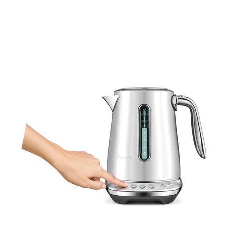 Person using Smart Kettle Luxe 7-Cup Water Heater In Brushed Stainless Steel With Temperature Control For Perfect Tea Or Coffee Brew