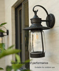 Rock Solid Outdoor Wall Lantern With Slick Industrial Design And Transparent Bubble Glass Shade Featuring A Top Shelf Led Filament Bulb For Sweet Porch Lighting And Dreamy Patio Vibes In Heavy Duty Black Coating mounted on outdoor wall with clear glass.