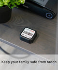 Radtrak³ Home Radon Detector For Long Term Testing 90 Days To 1 Year, Easy To Use Setup on a shelf next to a plant