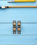Tight Stainless Steel Sliding Door Rollers Engineered For Dead Quiet Glide Action On Modern Glass Tracks With Heavy Duty Bearings on blue background.