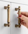 French Style Antique Brass Cabinet Pulls 3 Inch Center To Center Solid Metal Drawer Handles close up hand demo on cabinet